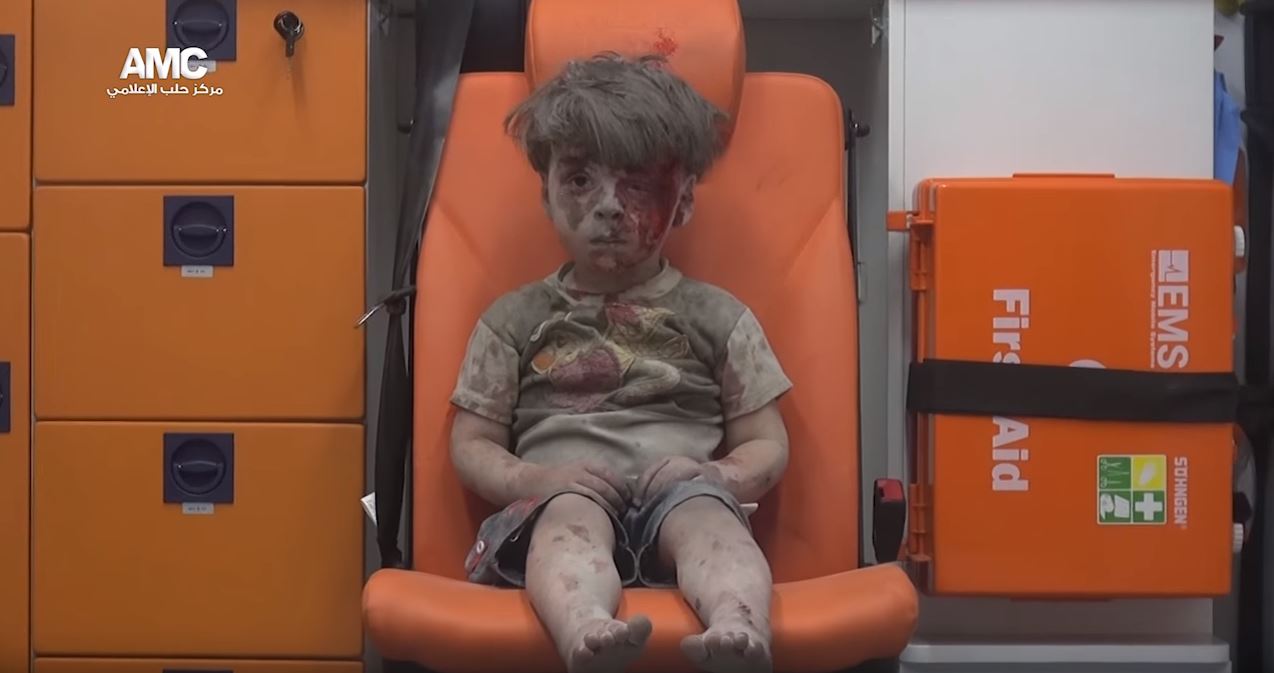 Omran Daqneesh, five years old, rescued after a bomb attack on his home in Allepo, Syris (courtesy of Allepo Media Center)